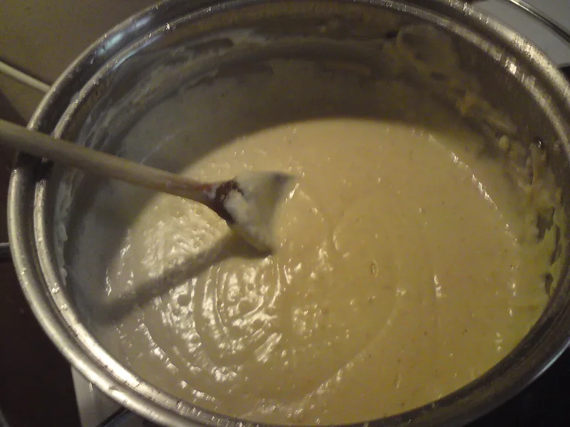 Saus putih kental dari tepung, mentega, dan susu diaduk dengan sendok kayu di dalam panci